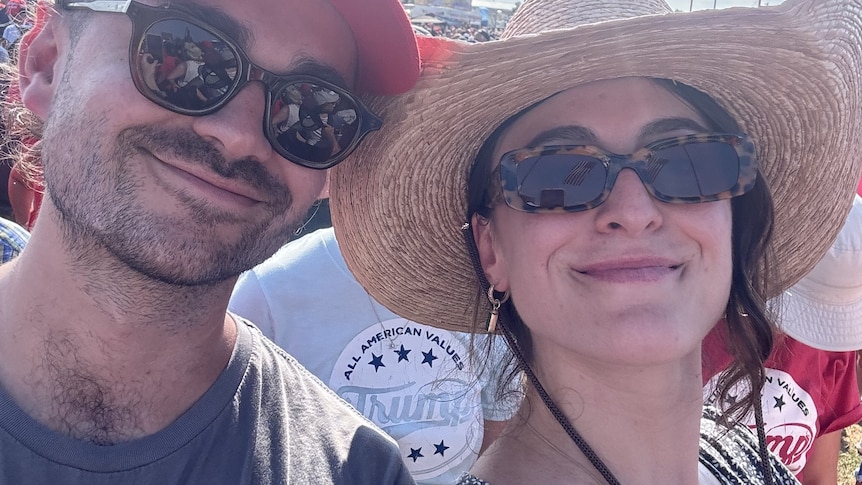 A young woman in a staw hat next to a man in sunglasses 