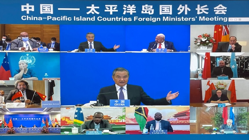 A video link screen shows a group of foreign ministers in an offical meeting