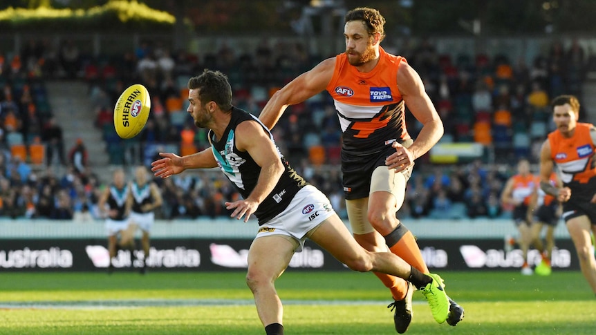 Sam Gray of the Power gets the ball ahead of Shane Mumford of the Giants (R) on April 15, 2017.