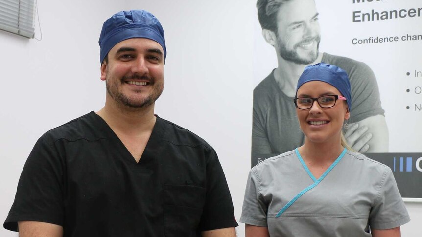 Dr Gavin Scriven and nurse Madeline Firkins sitting on a hospital bed