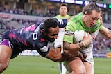 Charnze Nicoll-Klokstad tries to shrug the tackle of Justin Olam, who has one hand on his shoulder and one around his waist