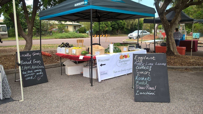 A small stall with several boxes of fruit and vegetables.