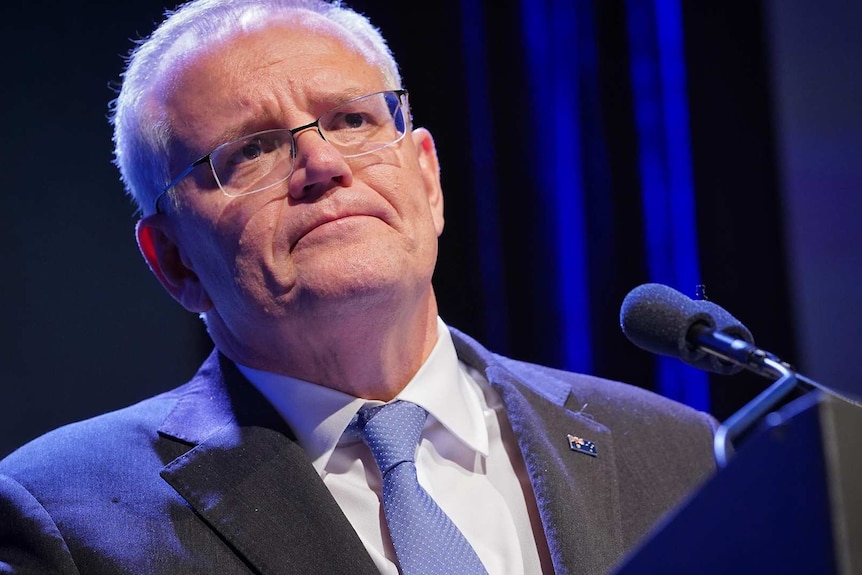 Scott Morrison stands in front of the podium and listens to questions during the press conference.