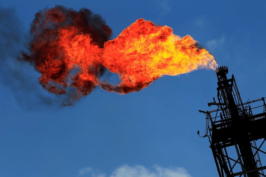 An LNG flare flames out from a stack.