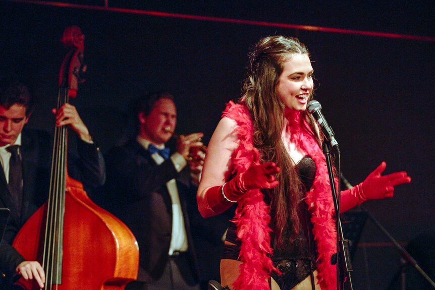 Cast member Sinead O’Hara delivers a number during the show, with two musicians in the background.