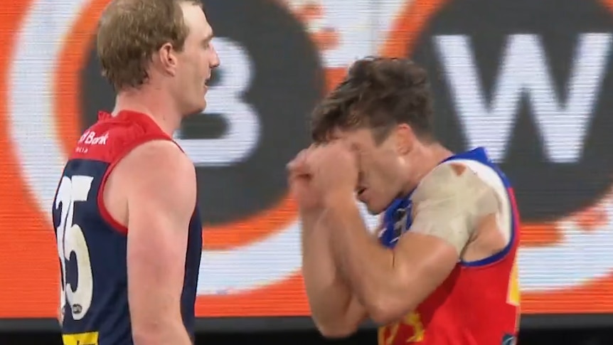 A player mimics crying as a sledge to another AFL player during a match