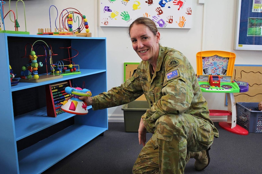 Lieutenant Colonel Sara Molloy wears army uniform as she tidies toys inside the Geckos Family Centre