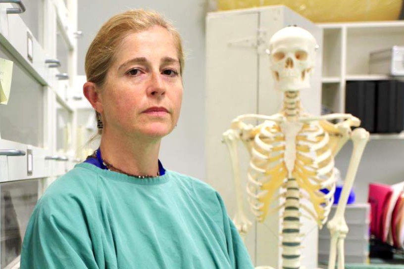 Dr Soren Blau stands in front of a skeleton.