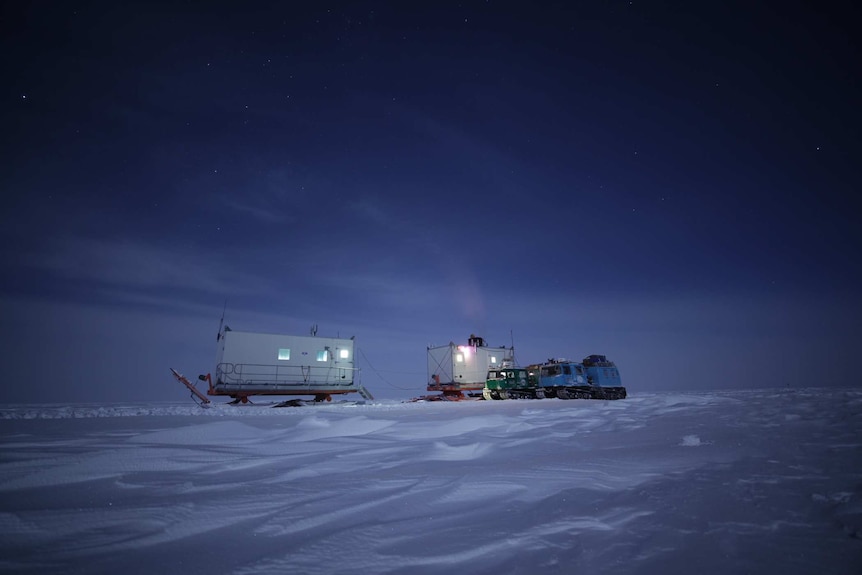 Picture of snow vehicles at night.