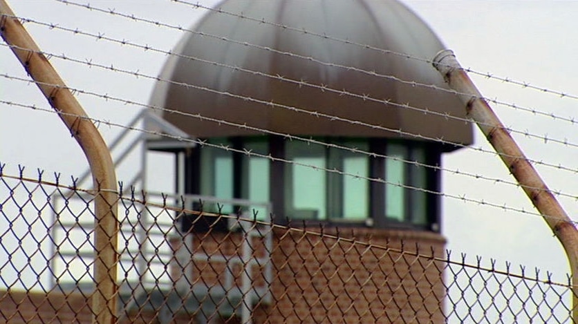 Prison look-out tower behind a barbed-wire fence