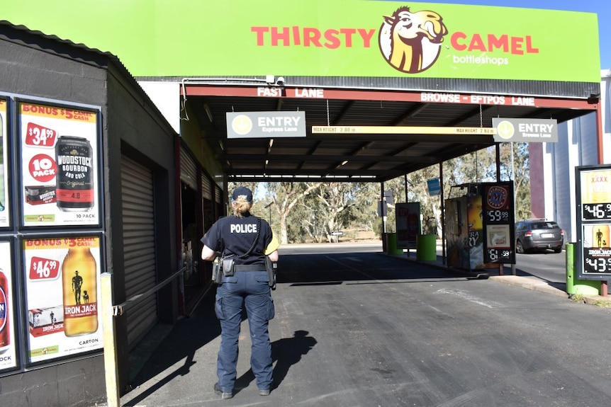 A police auxiliary at a drive-through bottle shop in Alice Springs.