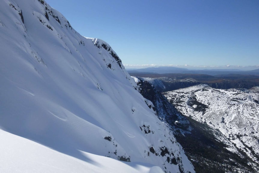 A snow-capped Cradle Mountain can be a dangerous place for skiiers and hikers.