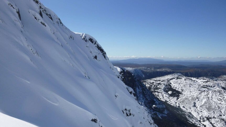 A snow-capped Cradle Mountain can be a dangerous place for skiiers and hikers.
