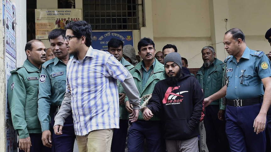 Police lead handcuffed men away.