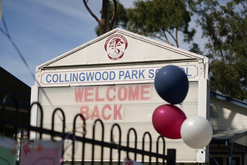 A sign outside a school says welcome back.