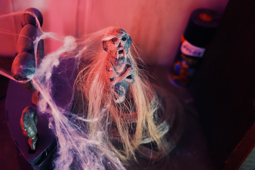 A haunted house prop of a doll with long hair.