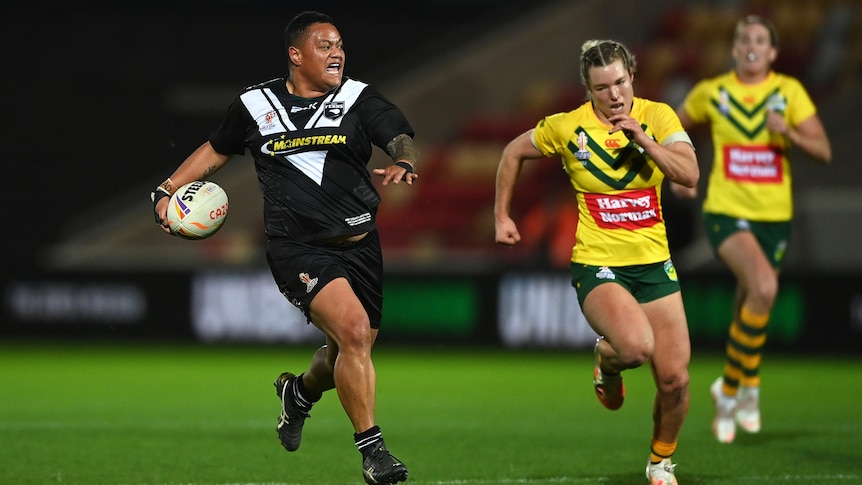 Mele Hufanga of the New Zealand Kiwi Ferns is chased by Australian Jillaroos' Emma Tonegato during the Rugby League World Cup.