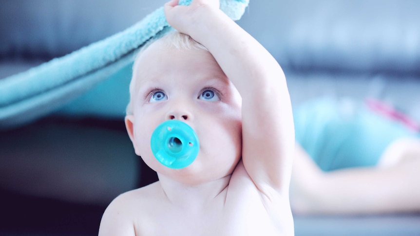 A child with a dummy in its mouth