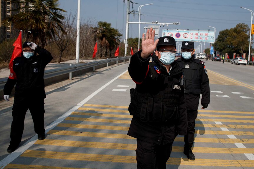 A security guard holds up his hands on a street in China