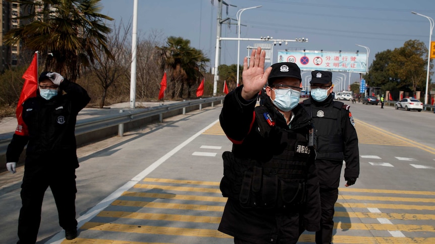 A security guard holds up his hands on a street in China