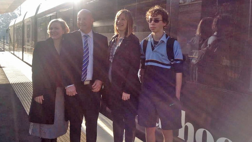 Verity Firth, John Robertson, Jo Haylen and school student at Waratah Hills station in front of light rail, 24/07/2014