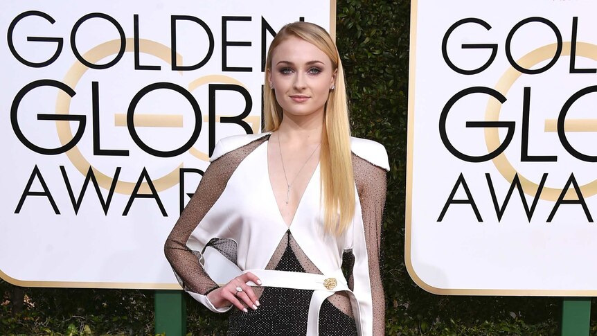 Game of Thrones actress Sophie Turner on the red carpet wearing a long black and white split gown