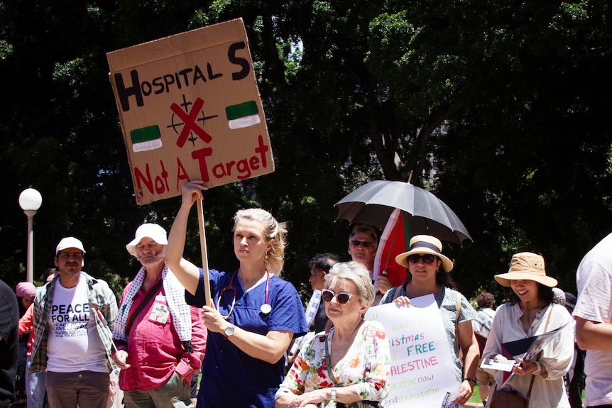Nurse holds a placard at Sydney pro-Palestinian protest on sunday november 3