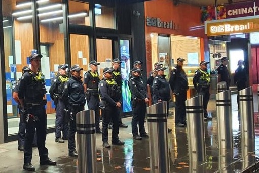 About a dozen Victoria Police officer stand in rows outside the Melbourne East Police Station.