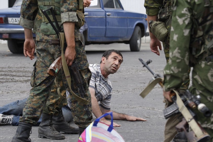 Russian soldiers detain a man who carried a weapon in his car at a checkpoint in Gori, South Ossetia