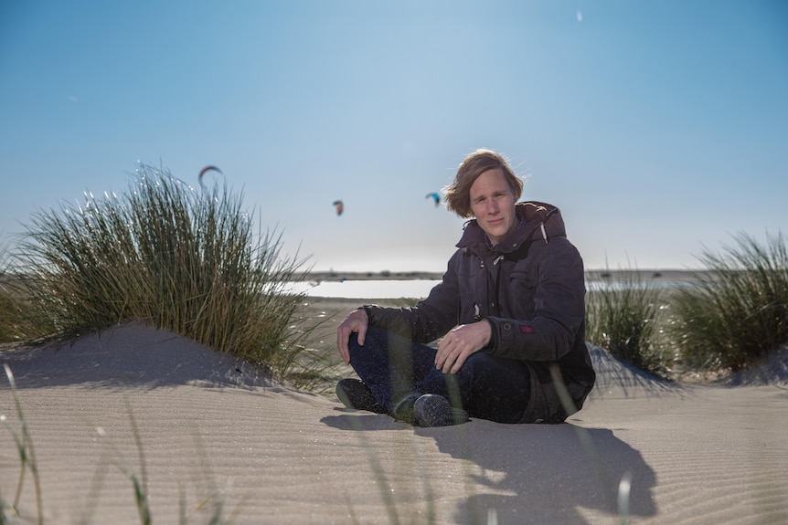 Coastal engineer Sierd de Vries sits in sand dunes in the Netherlands.
