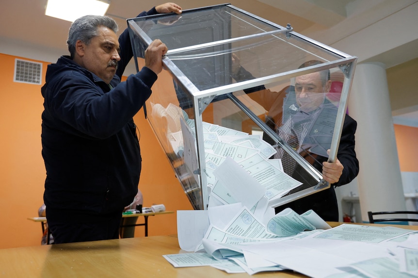 在乌克兰顿涅茨克举行是否加入俄罗斯的公投结束后，选举委员会的成员们正在清空投票站的投票箱
