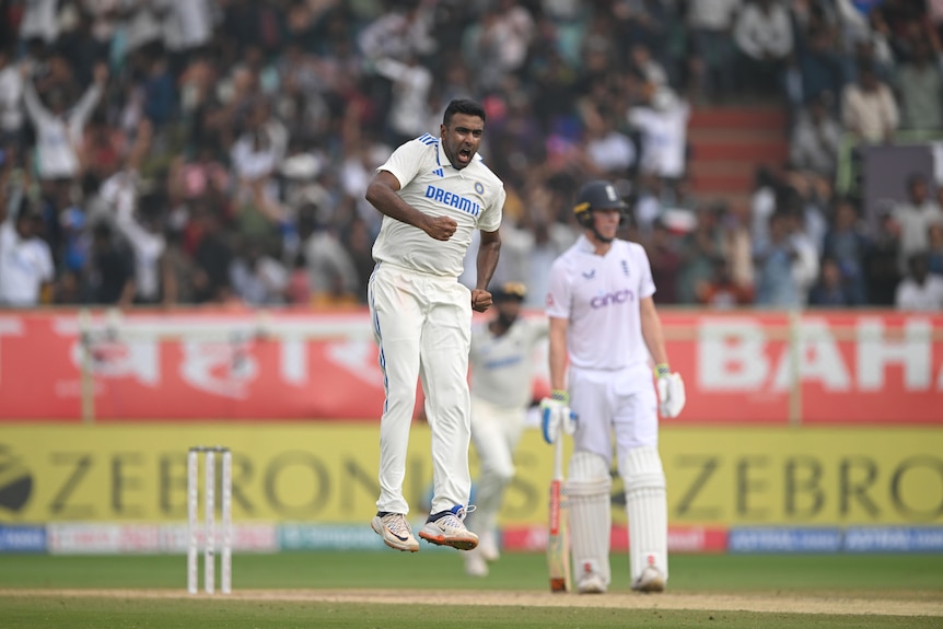 An Indian bowler jumps up in the air in delight after taking a wicket in a Test match.