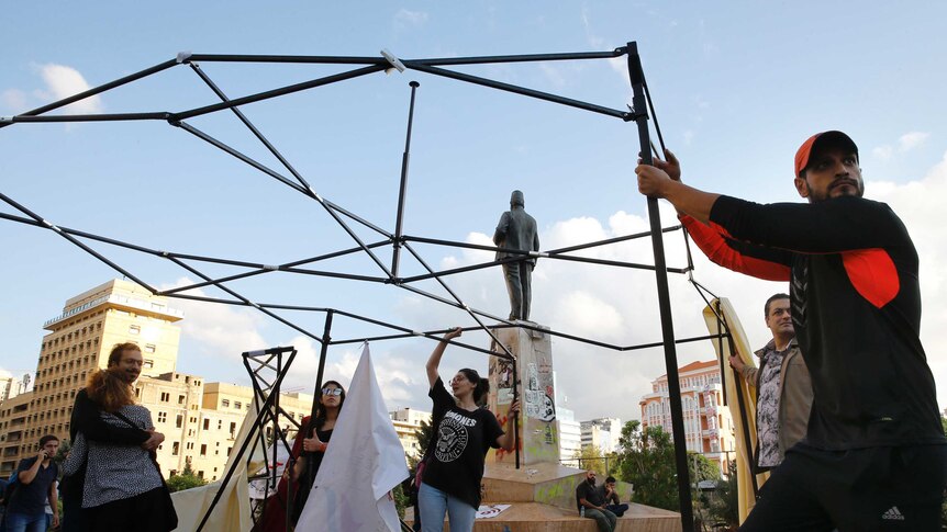 People erect tents in a town square.