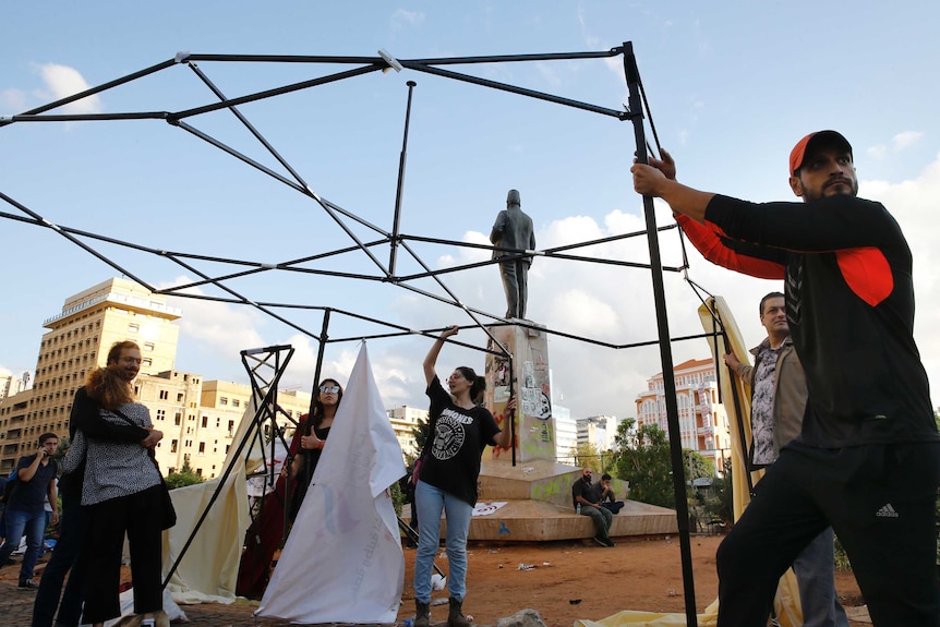 People erect tents in a town square.