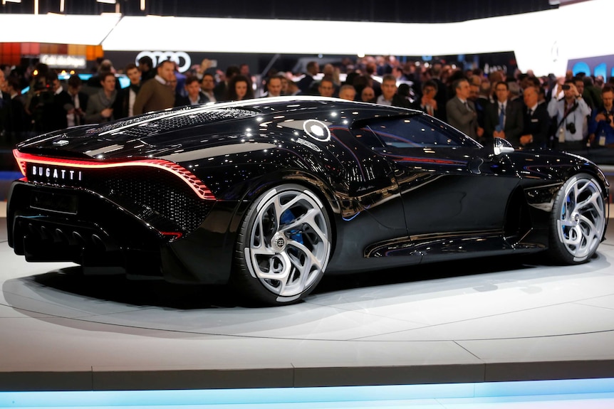 A shot from the side of the Bugatti La Voiture Noire with crowds admiring it in the background.