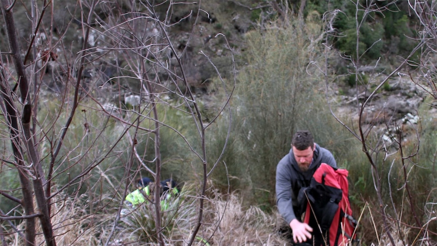 Police officer carries a backpack containing a rescued dog