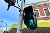 A green walking man icon to cross the street