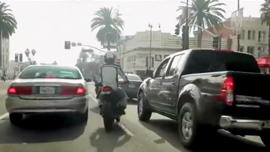 Motorcyclist weaves through traffic