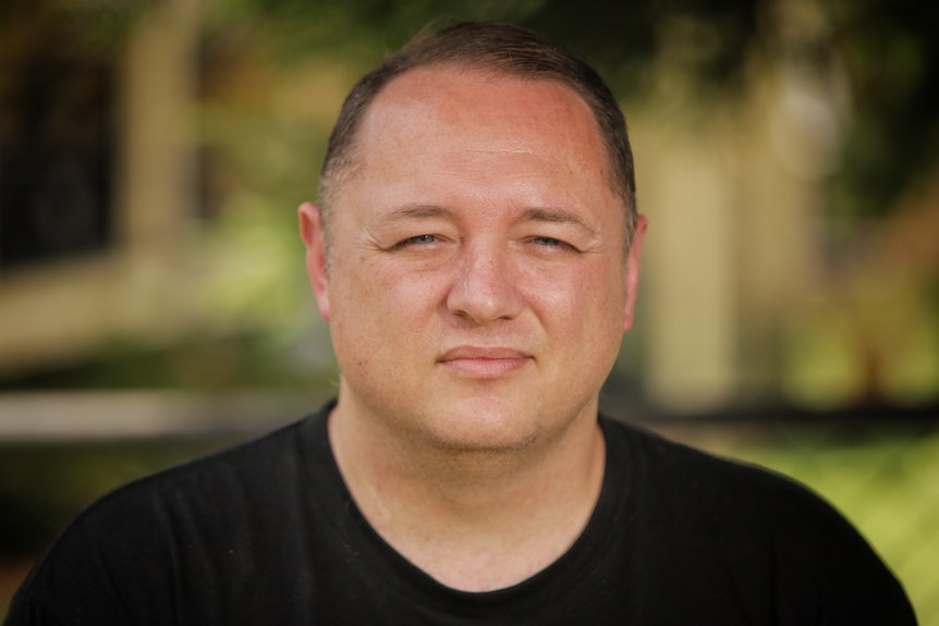 A man wearing a black t-shirt.