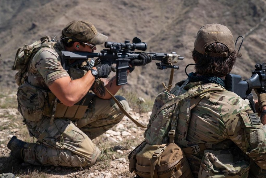Two US Special forces soldiers with military rifles ready to fire at ISIS forces in Afghanistan.