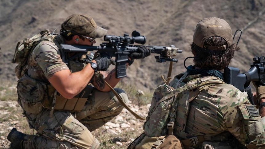 Two US Special forces soldiers with military rifles ready to fire at ISIS forces in Afghanistan.