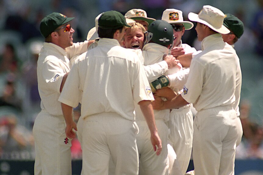 Shane Warne is hugged by Australian Test teammates after taking a hat-trick at the MCG.