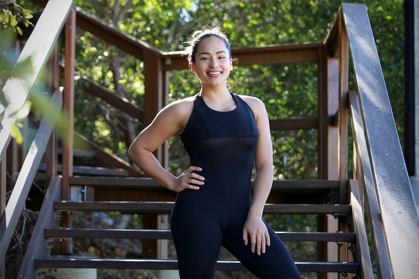 Lisa Trujillo stands in a public stairway smiling at the camera.