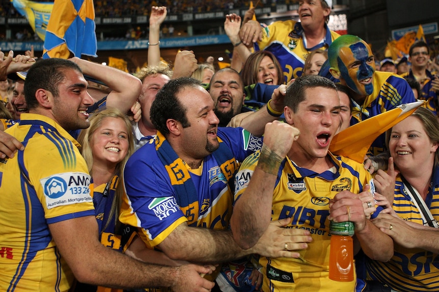 A man celebrates with fans following an NRL match
