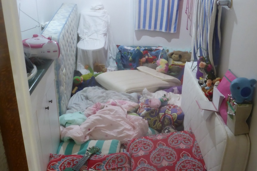 A bathroom covered in mattresses and towels.