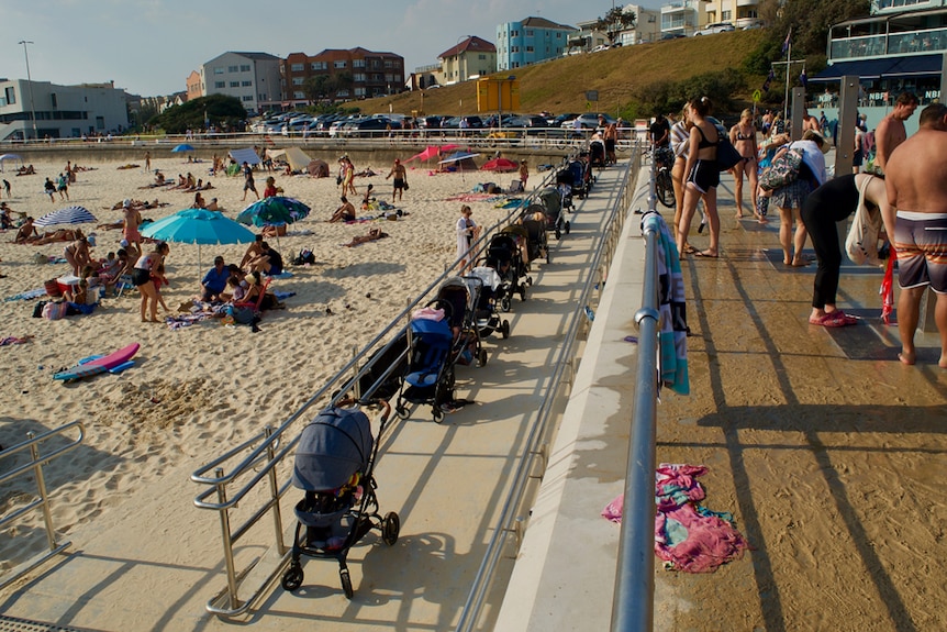 The access ramp to Bondi Beach is clogged up with more than 10 prams parked one behind another