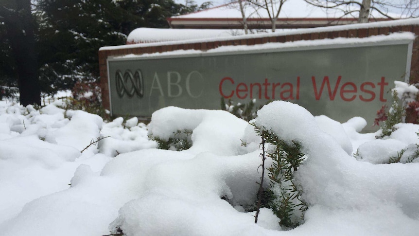A sign saying ABC Central West outside a building covered in snow