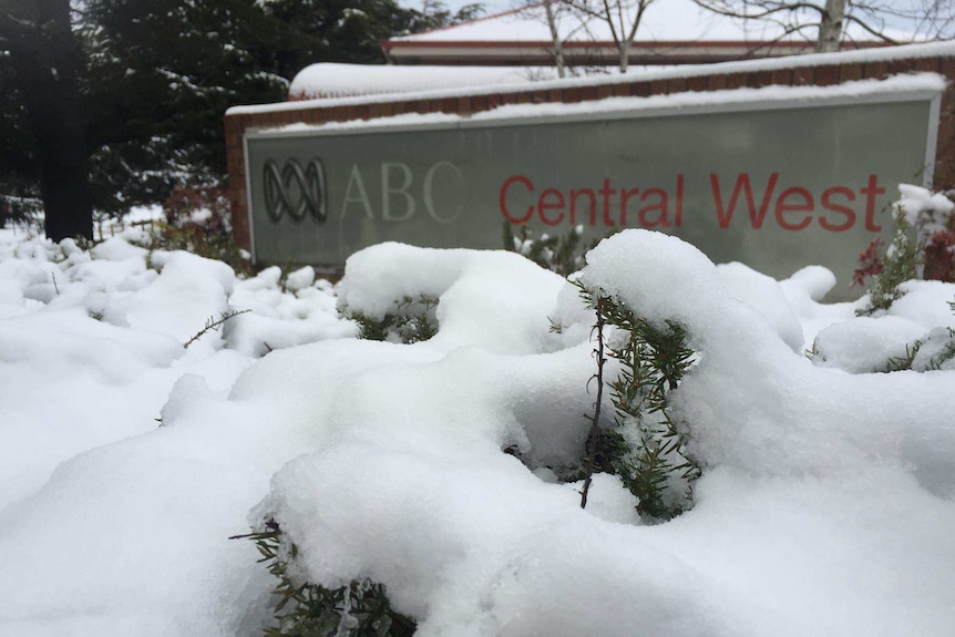 A sign saying ABC Central West outside a building covered in snow