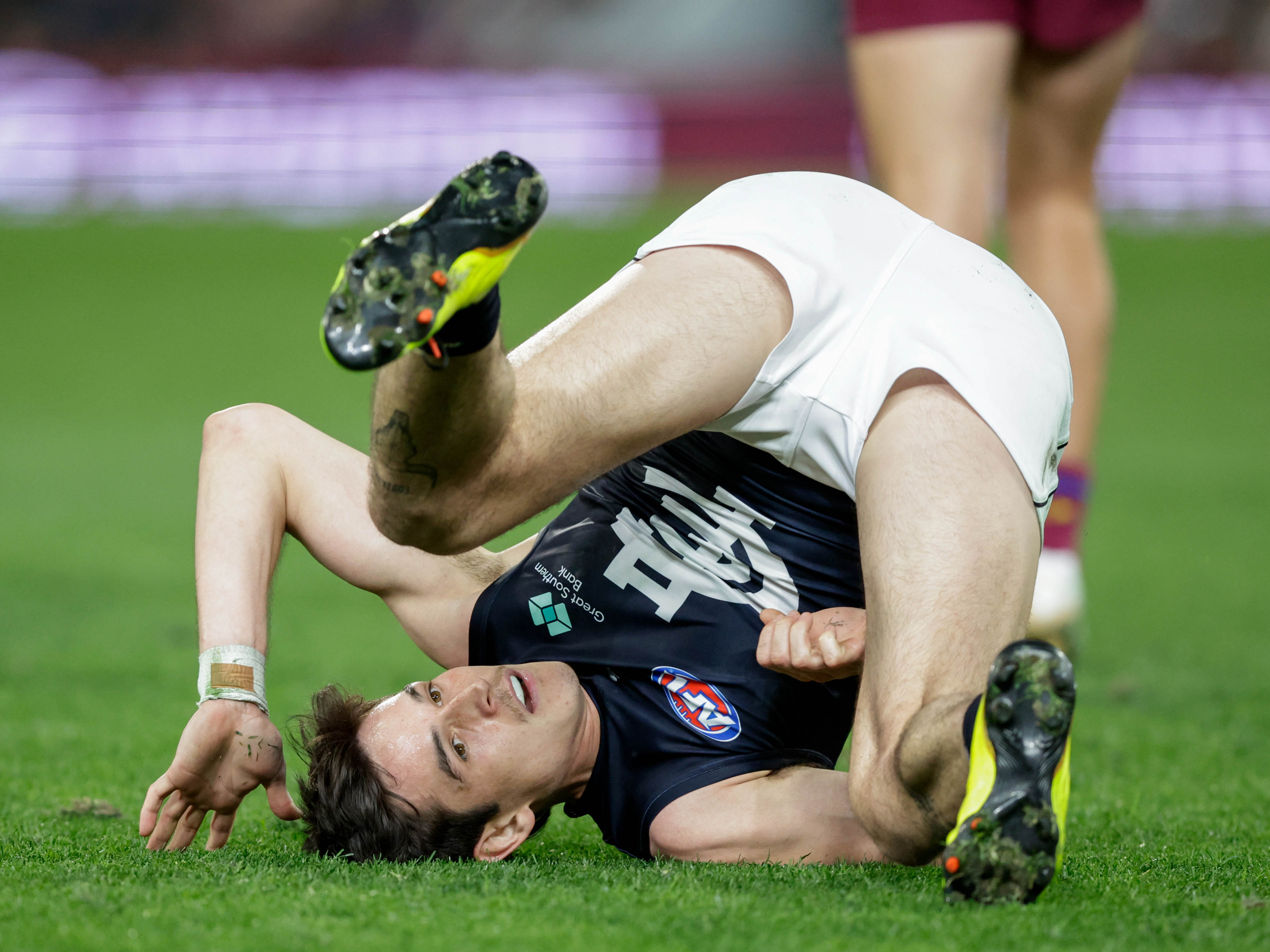 Zac Fisher is rolled onto his back and shoulders with his backside in the air