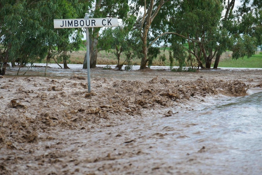 Fast-moving water from flooded Jimbour Creek cuts off road to Jandowae.